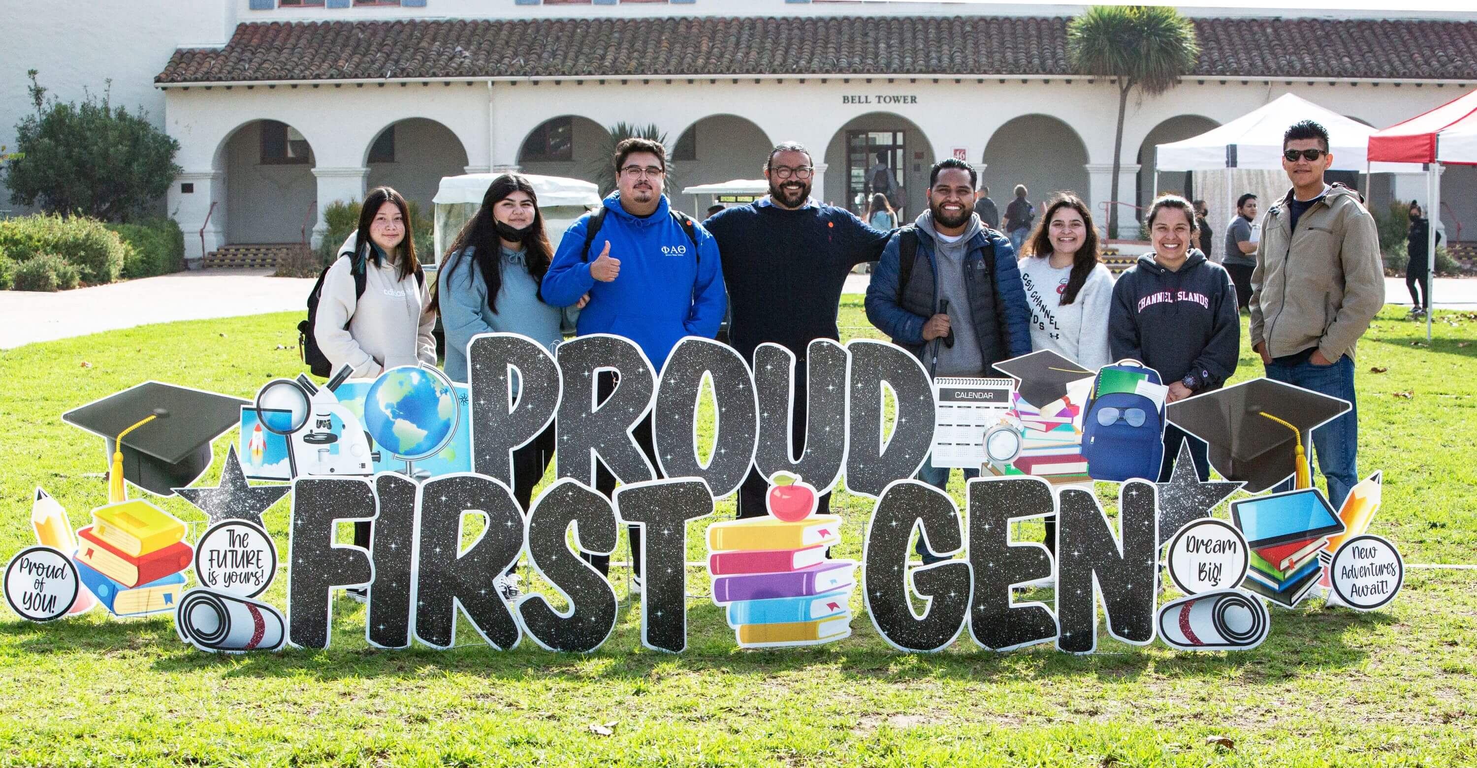 a group of college students holding up a proud first gen sign