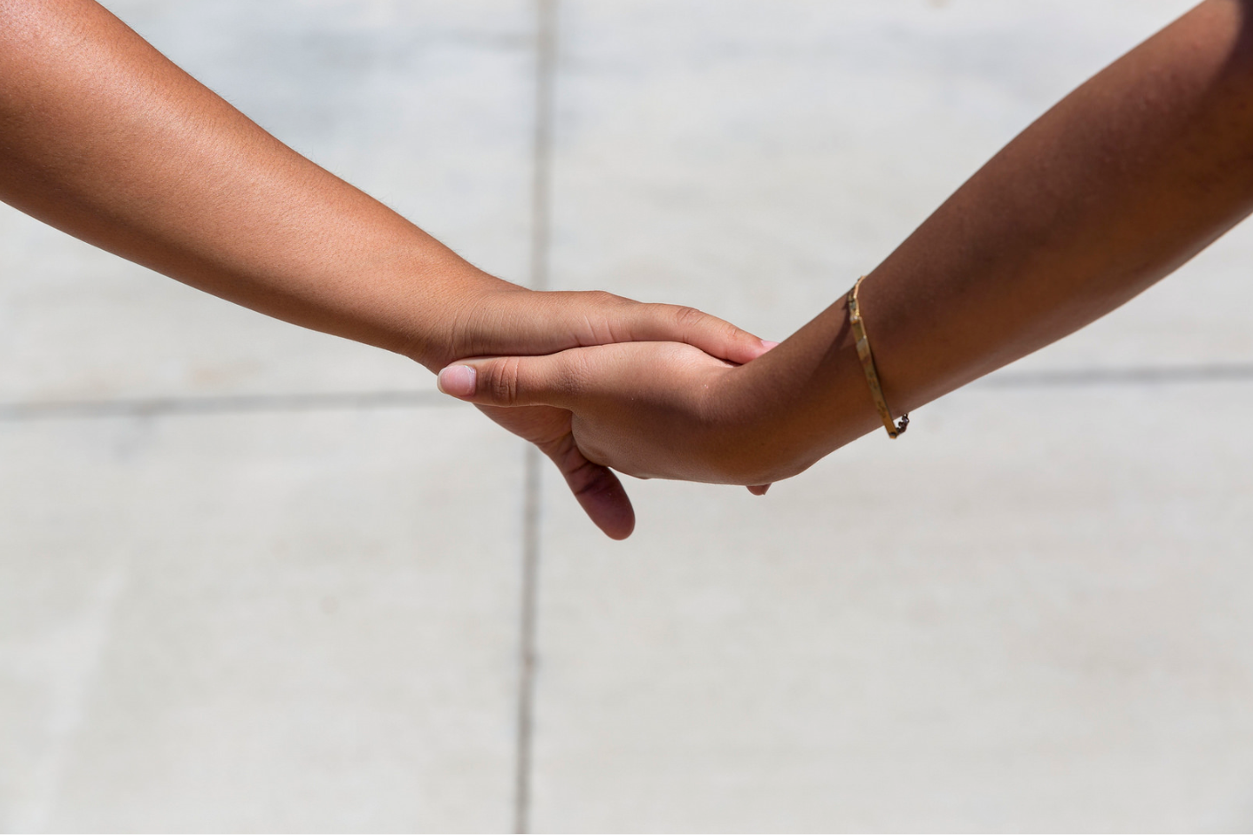 A close up of two people holding hands but just the hands and wrists