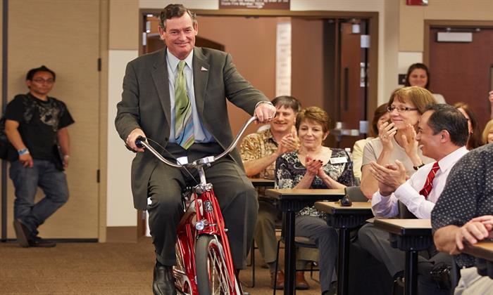 Chancellor White riding a bike into Chico State in 2013.