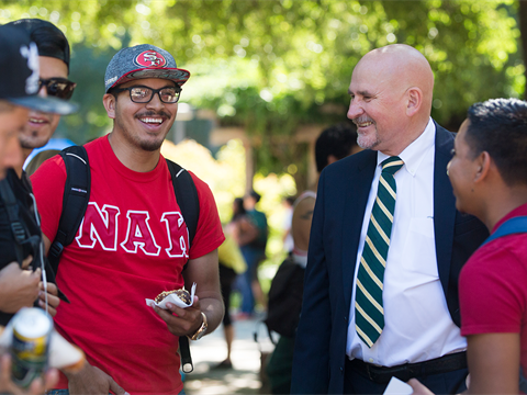 Sacramento State University President Nelson smiling and talking with students