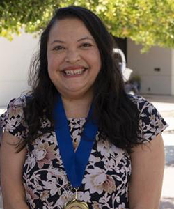 Michelle Gradowitz smiling with the CSUB President's medal around her neck.