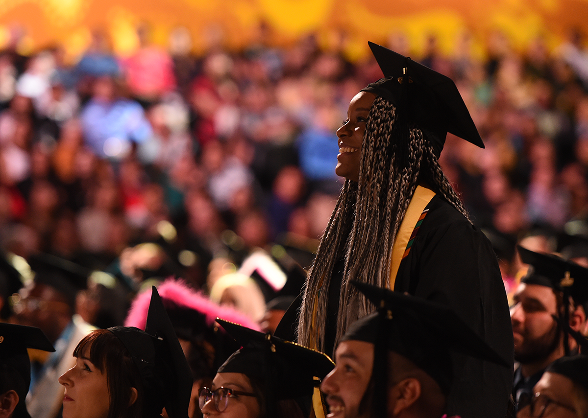 California State University student on the shoulders of another student during commencement ceremony
