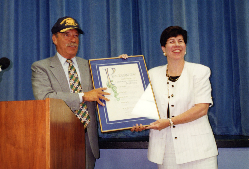 July 1995      Former CSU Chancellor Barry Munitz, Ph.D., presents former Cal Maritime President Mary Lyons, Ph.D., with a proclamation stating the campus officially joins the CSU.