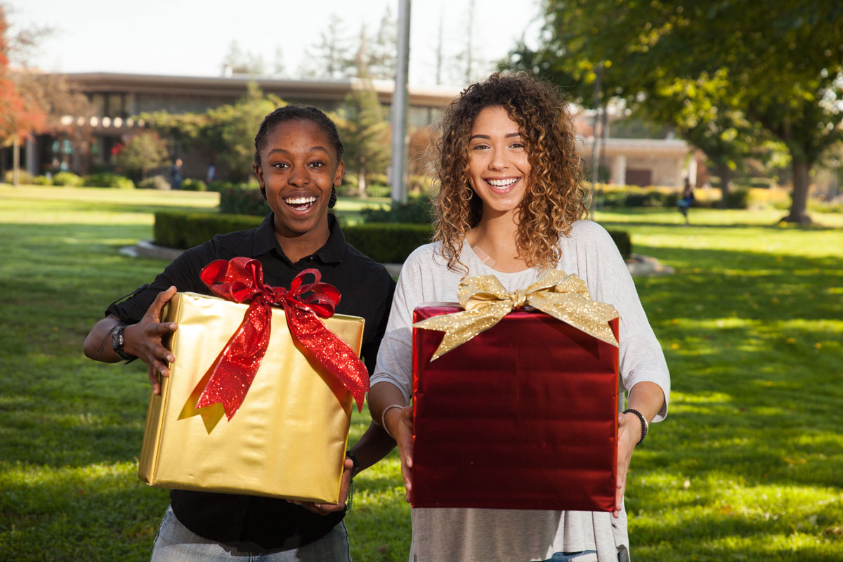  Stanislaus State student Mi’ShayeVenerable, left, and a fellow student posewith decorative gifts while getting ready forthe holidays on November 9, 2016.
