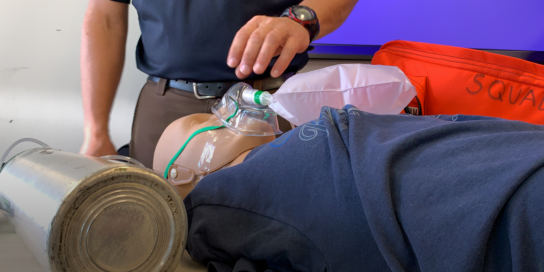 The EMT class practices putting an oxygen mask on a simulation mannequin.