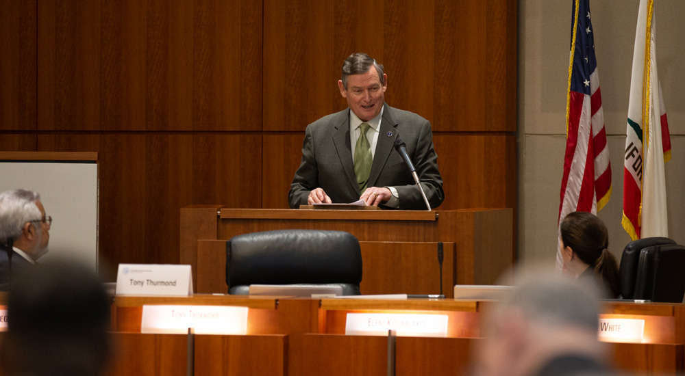 CSU Chancellor Timothy P. White speaks at a microphone.