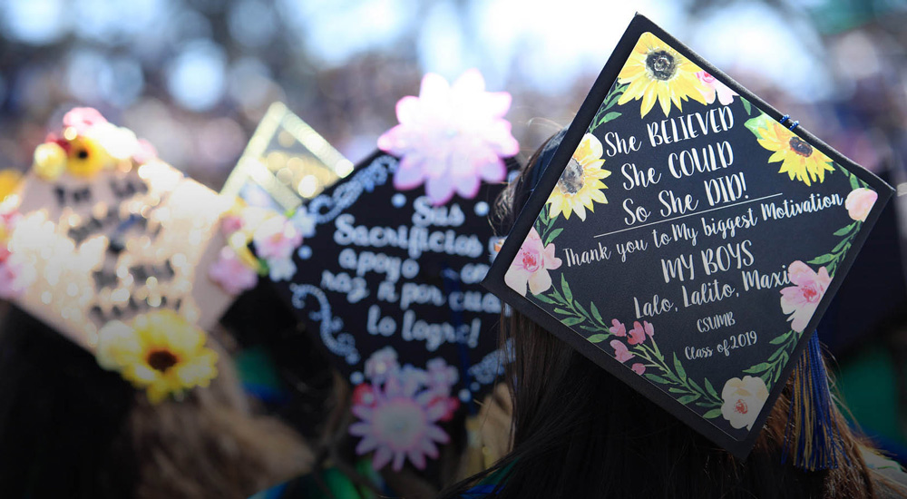 CSU graduates show off their decorated mortarboards.