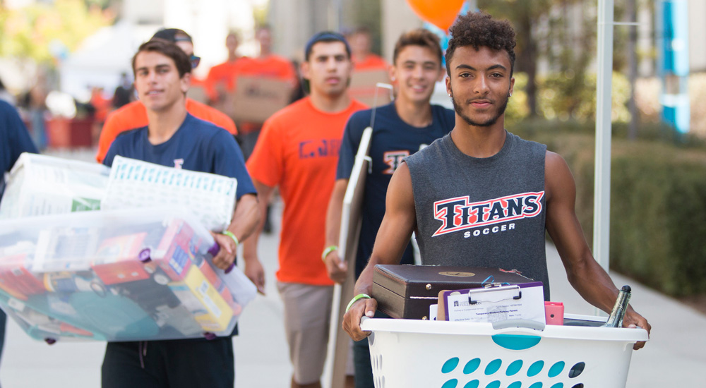 A group of students are shown moving into dorms.