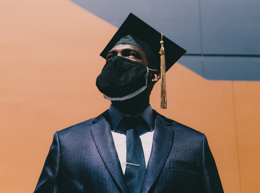 man with face mask wearing a graduation cap