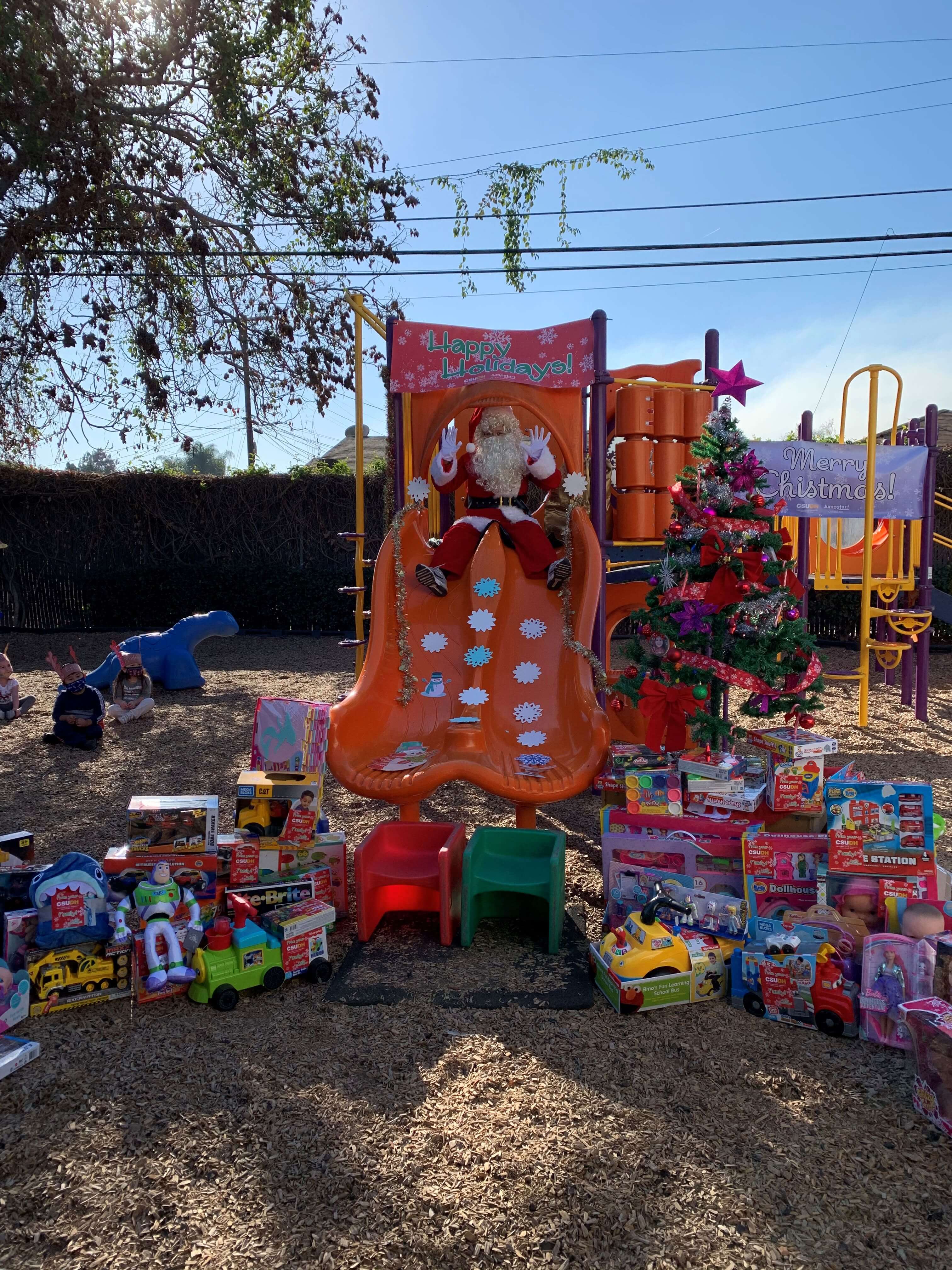Santa Claus visits a group of preschoolers to give out the gifts donated during CSUDH's 2020 Totes for Tots drive.
