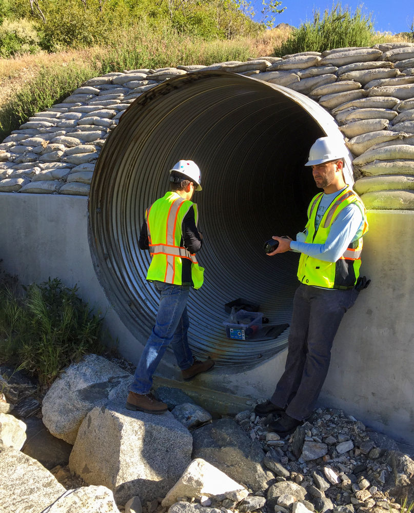 CSUN students work at the opening of a corrugated steel culvert.