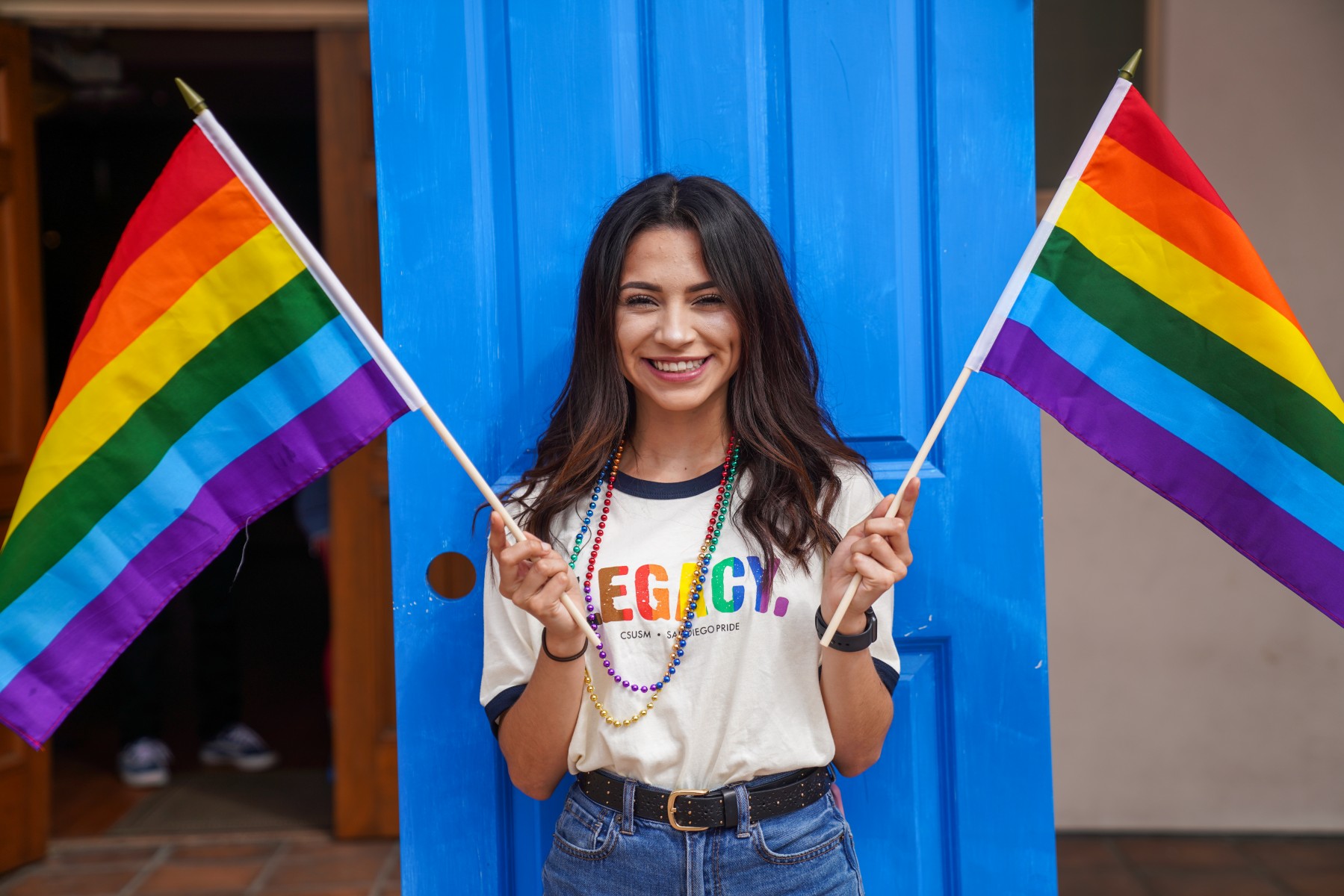 woman holding two rainbow flags