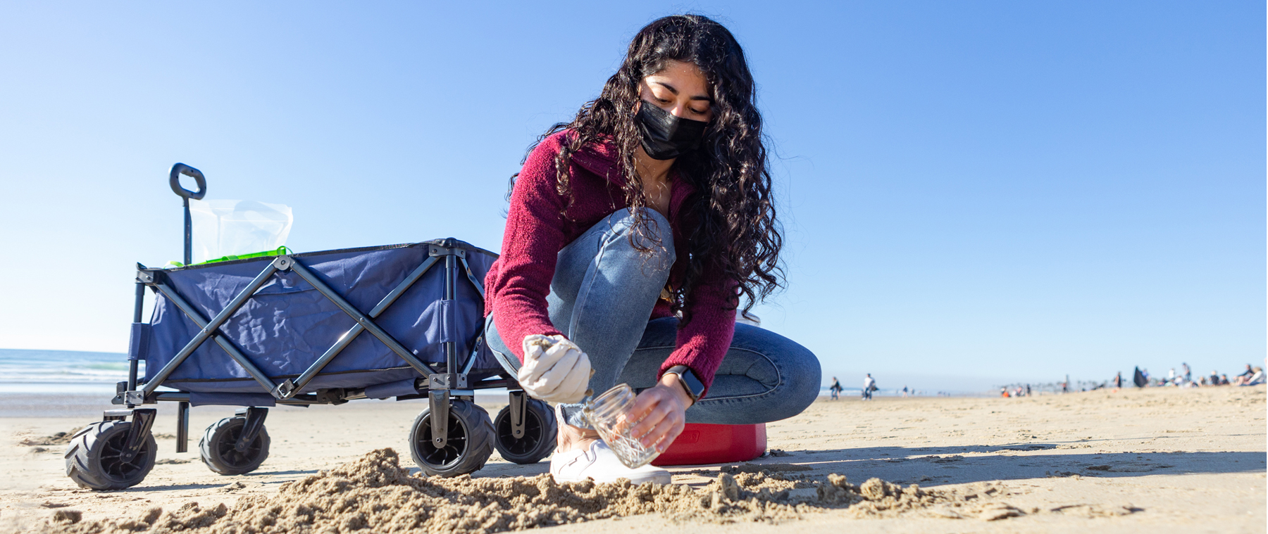 Student collecting sand samples at the beach