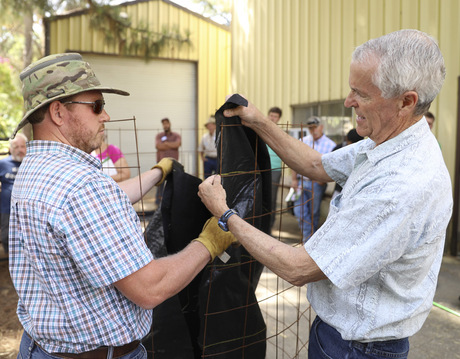  Johnson and farmer Daniel Unruh add black cloth to the bioreactor during the workshop.