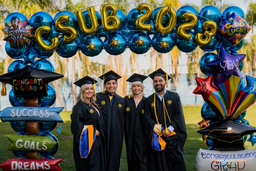graduating students in front of C S U B balloon sign