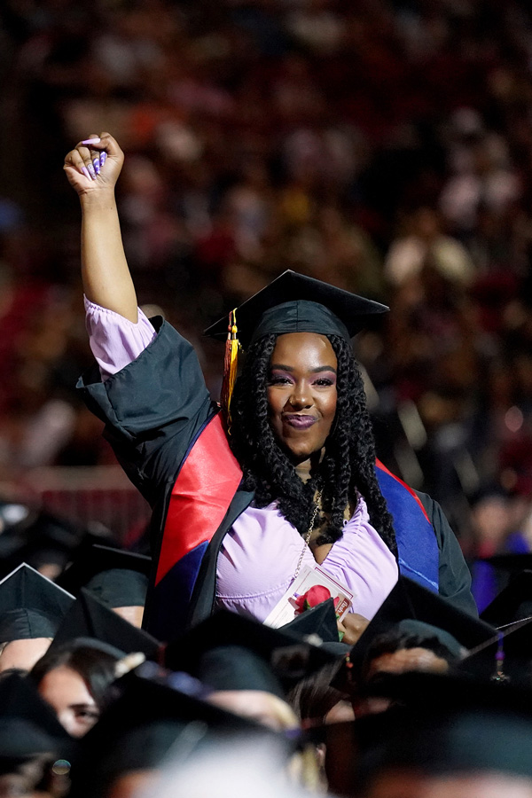 graduating student raises fist in celebration