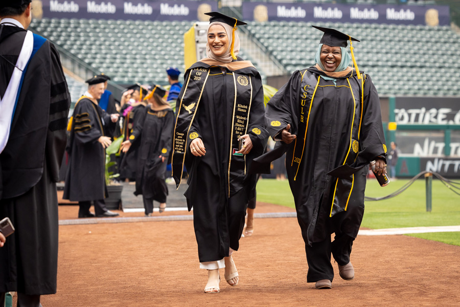 graduating students walking on baseball diamond