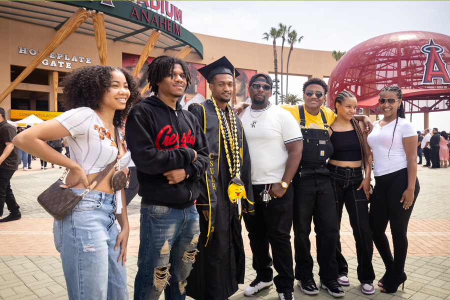 graduating student and family standing in front of angels stadium