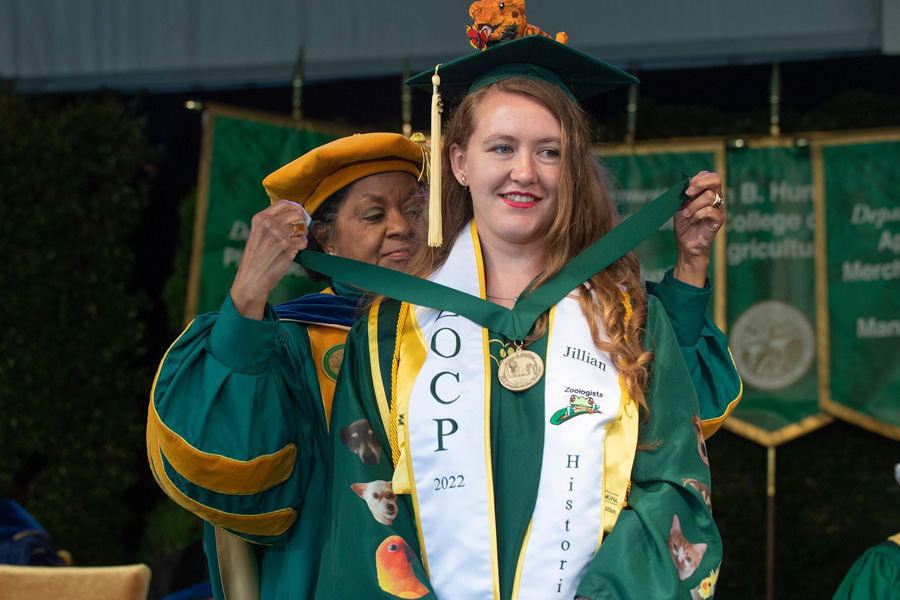 graduating student receives medal from cal poly pomona president soraya coley