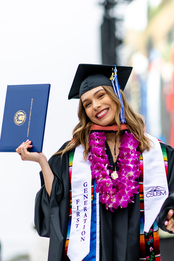 graduating student holding diploma up