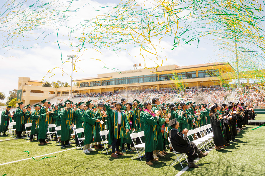 a crowd of graduating students with streamers flying over them