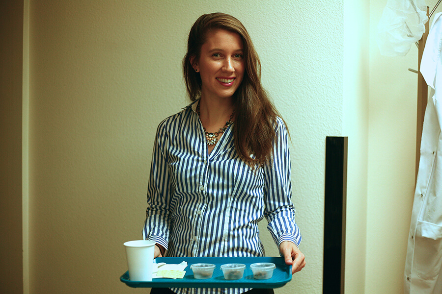 Maria Handley smiling and holding a tray of food and drinks