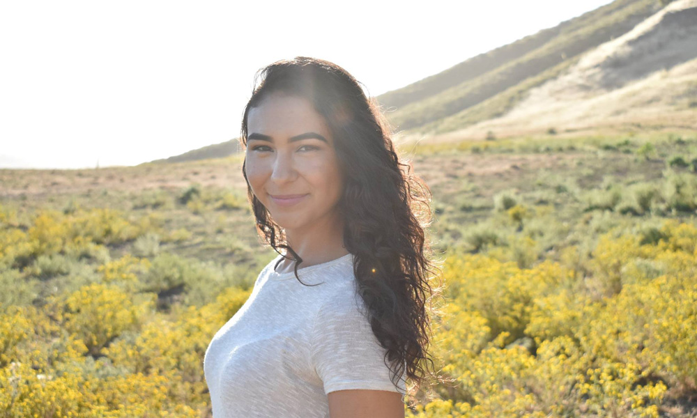 Gabriella “Gabi” Hernandez posing for camera in a field