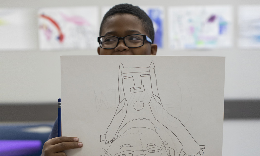 a student showing off drawing