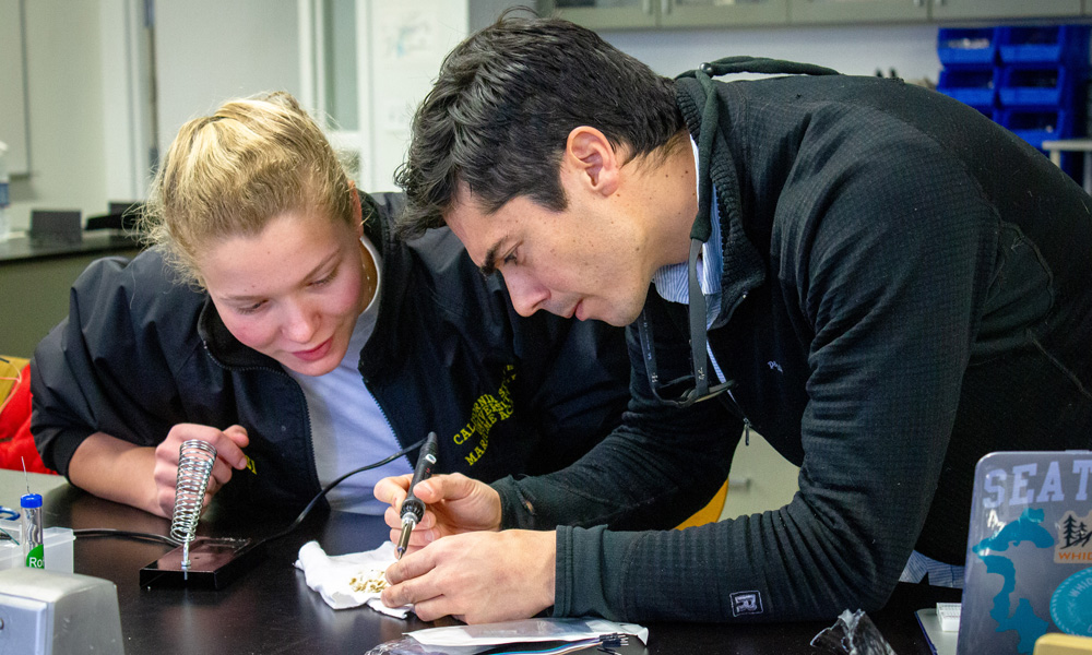 Dr. Alejandro Cifuentes-Lorenzen demonstrates soldering to a student