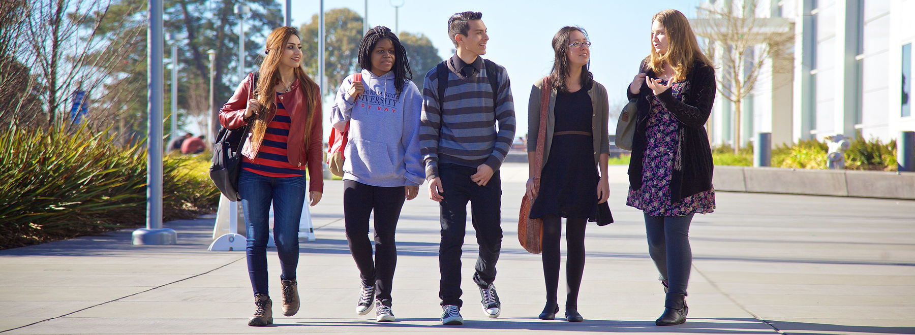 Five students walking on campus