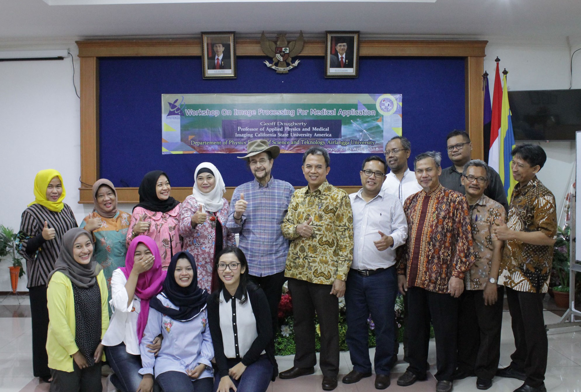 An American college professor posing with Indonesian men, and women wearing hijabs