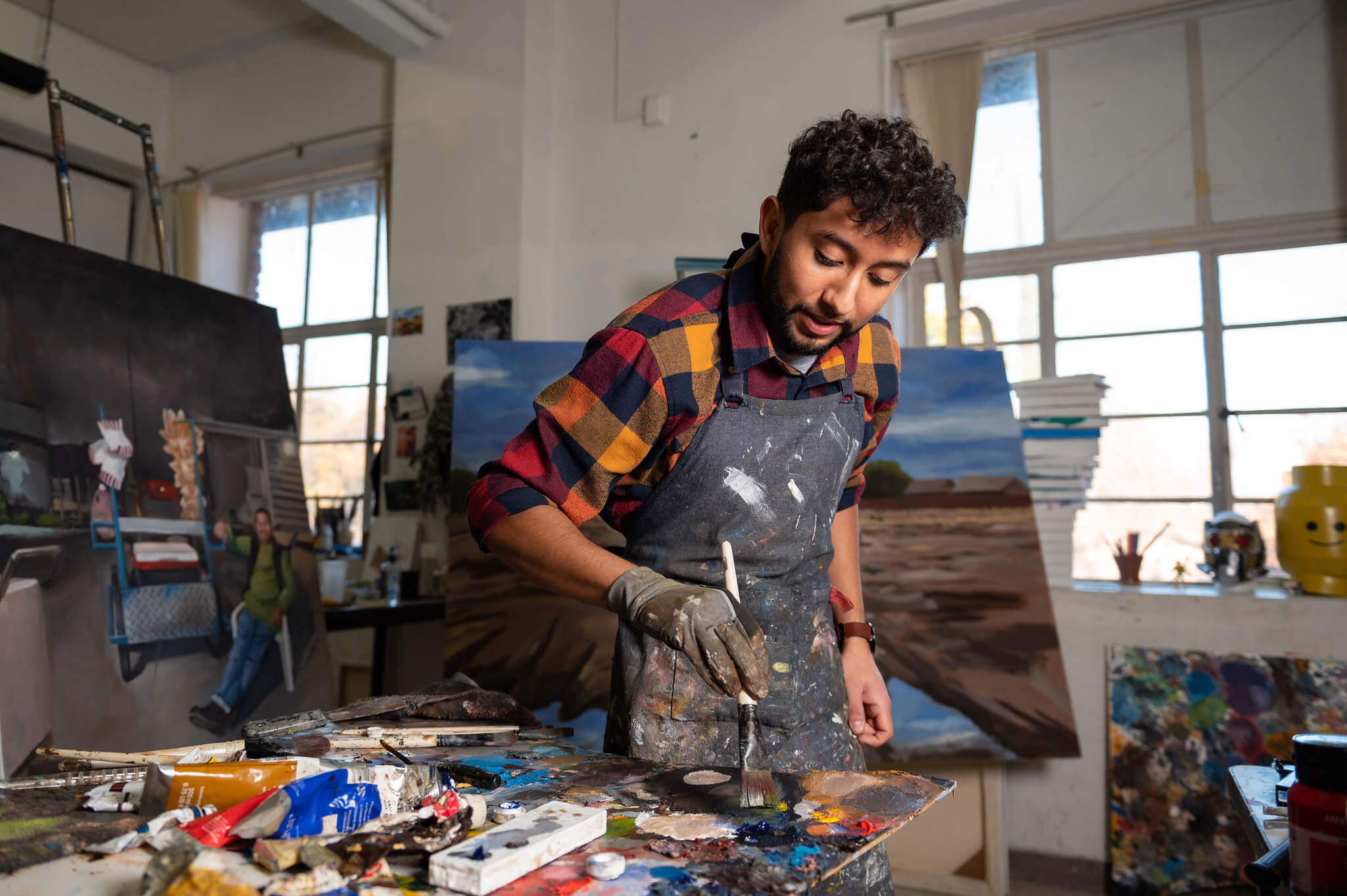 a college student mixing paint in an art studio