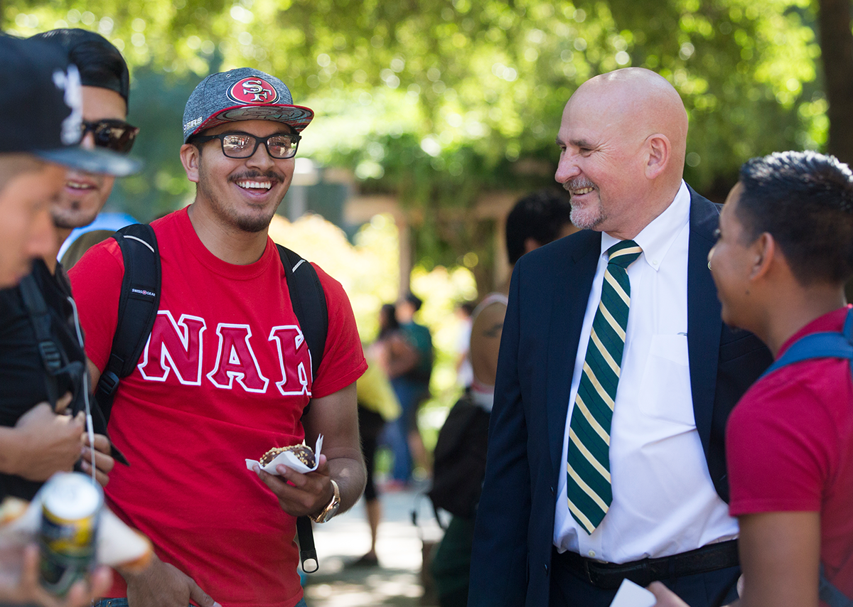 Sacramento State University President Nelson smiling and talking with students