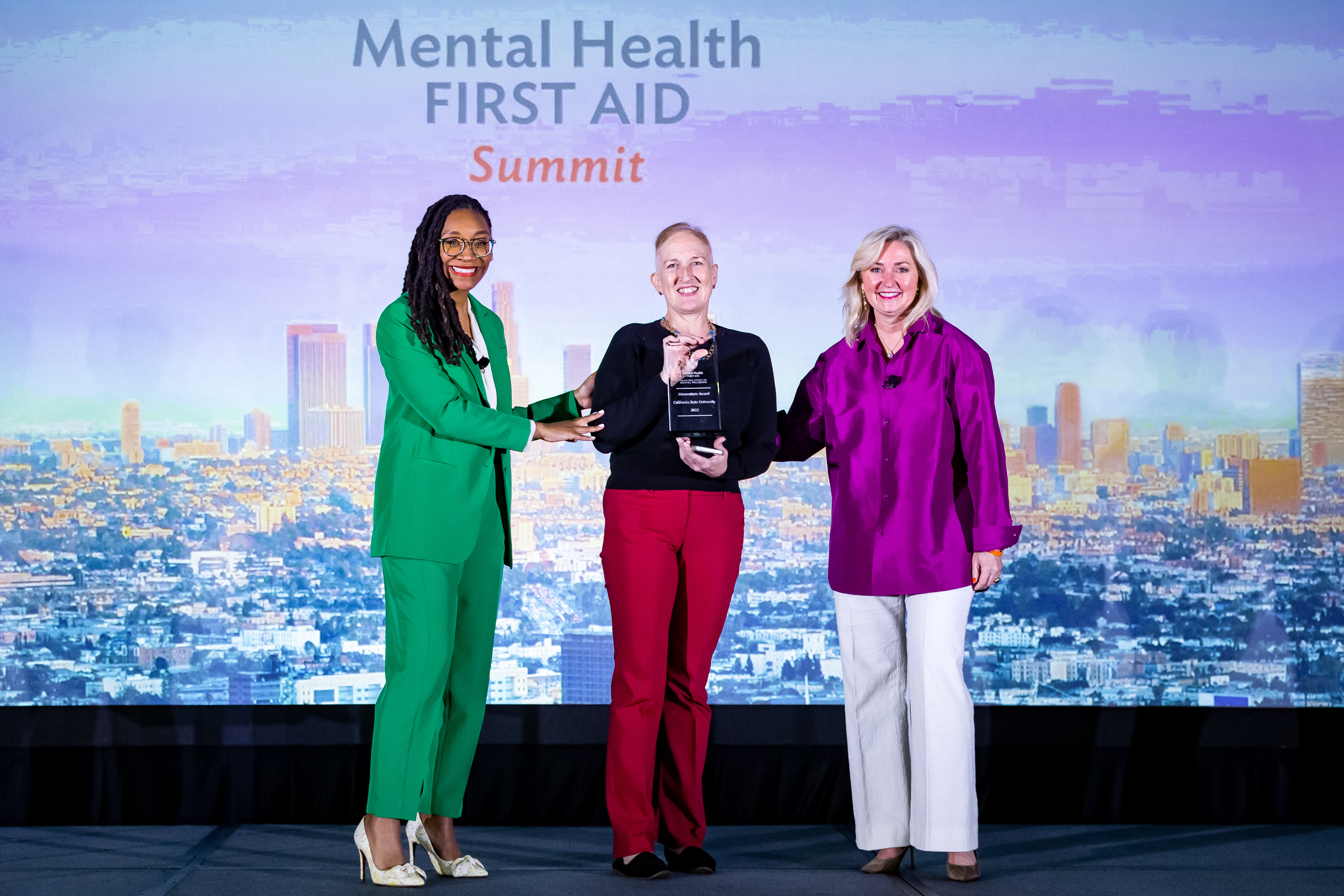 three women standing on stage