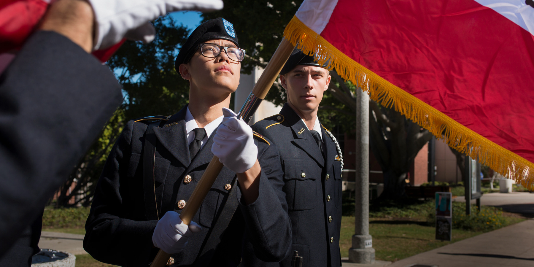 two military cadets perform a flag raising ceremony