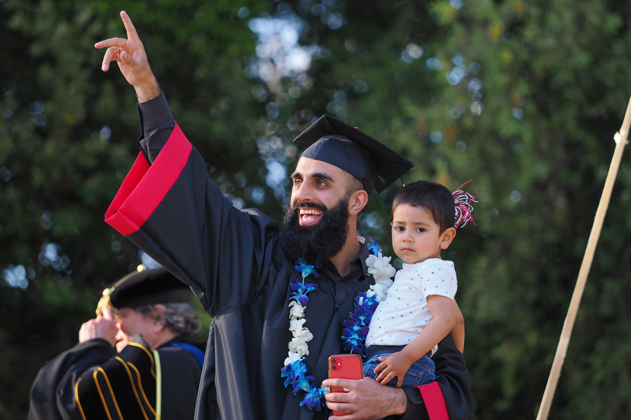 graduating student holding young son