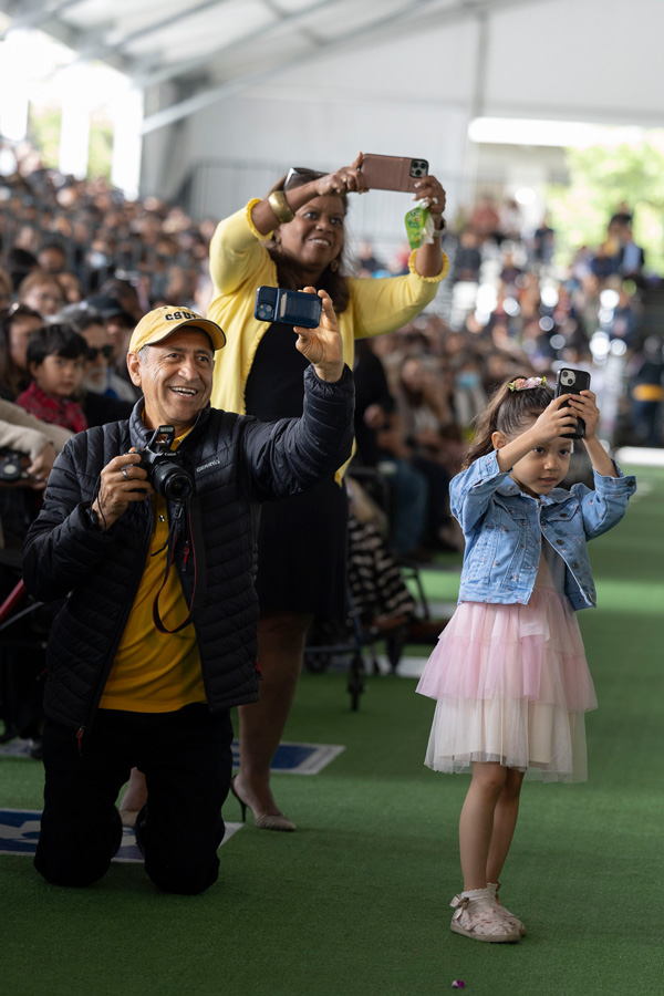 family of graduating student holding multiple cameras
