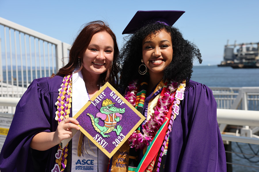 graduating student holds up cap that says later gator s f s u 2023