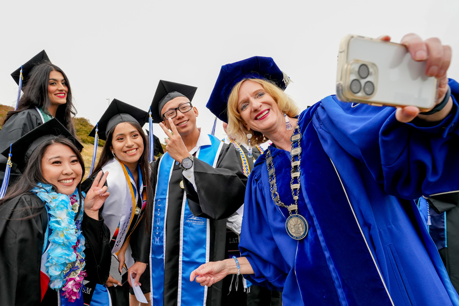 graduating students pose for a selfie with c s u san marcos president ellen neufeldt