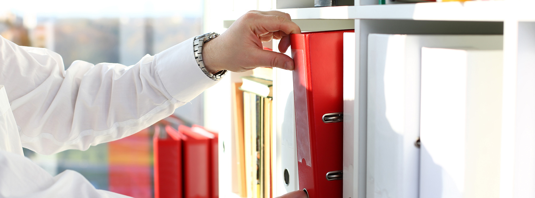 employee picking a red binder