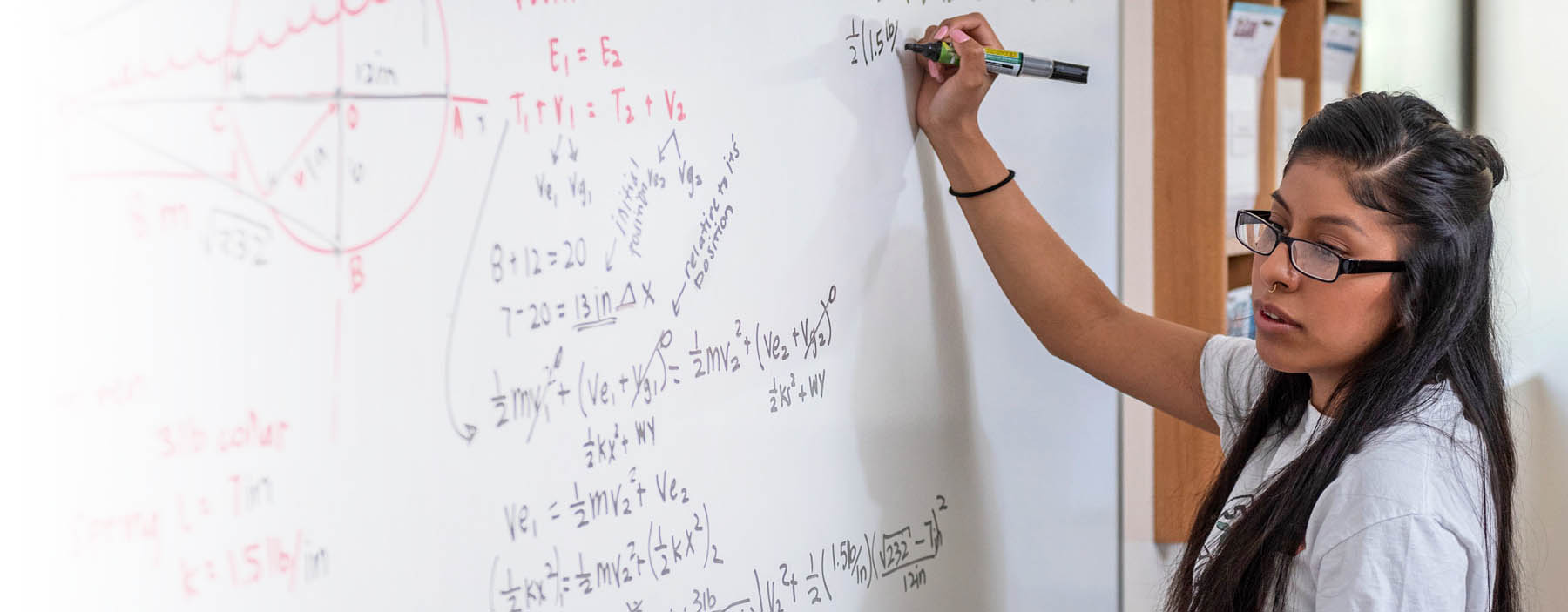 CSU student doing  math on a white board