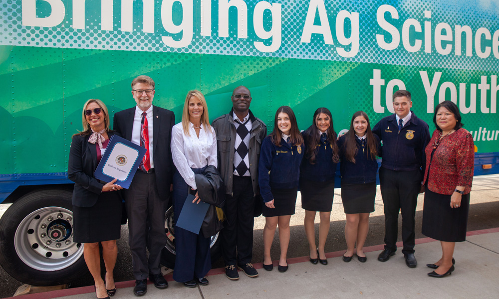 faculty and students from Stan State stand in front of their mobile AG classroom